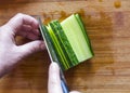 WomanÃÂ¢Ã¢âÂ¬Ã¢âÂ¢s Hands Cut Cucumber Ribbons with Santoku Knife on a Wooden Chopping Board. Salads, Nigiri Sushi, Pressed Sushi or Ro Royalty Free Stock Photo